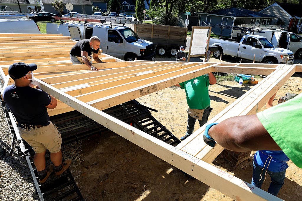 Pre-fabricated framing is unloaded at a Habitat for Humanity home build in Williamsburg