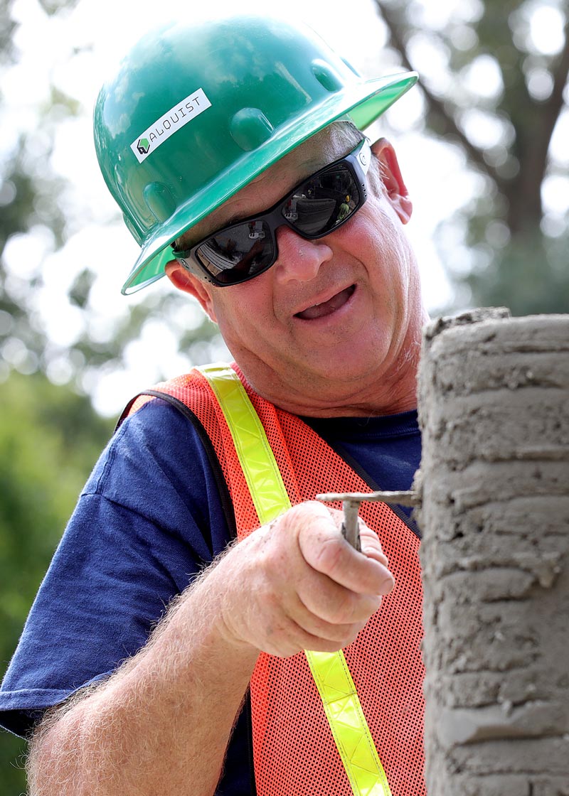 Habitat’s Craig Meadows keeps the cement looking good and the Alquiest 3D printer continues to lay down cement on the site of a Habitat for Humanity build in Williamsburg 