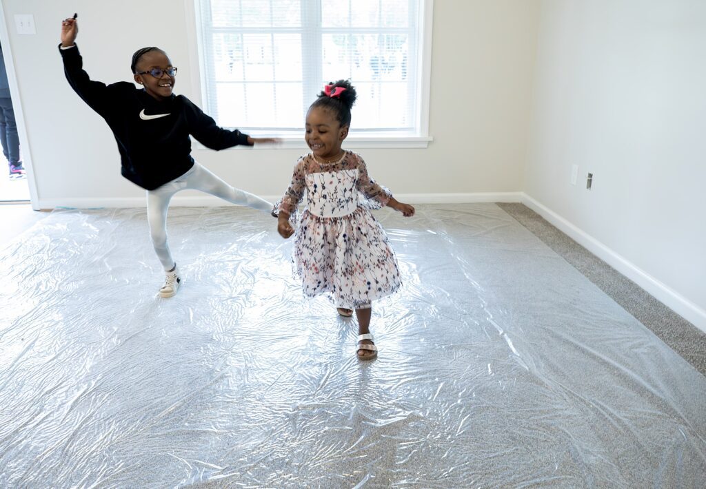 Children dancing in a newly built Habitat for Humanity home.