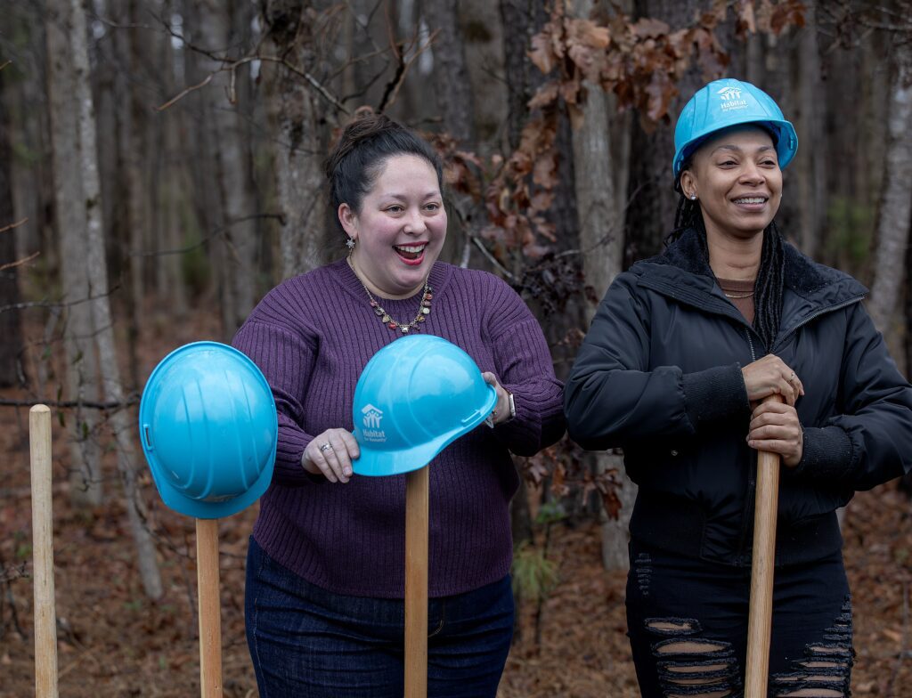 Volunteers with hard hats at a Habitat groundbreaking ceremony.
