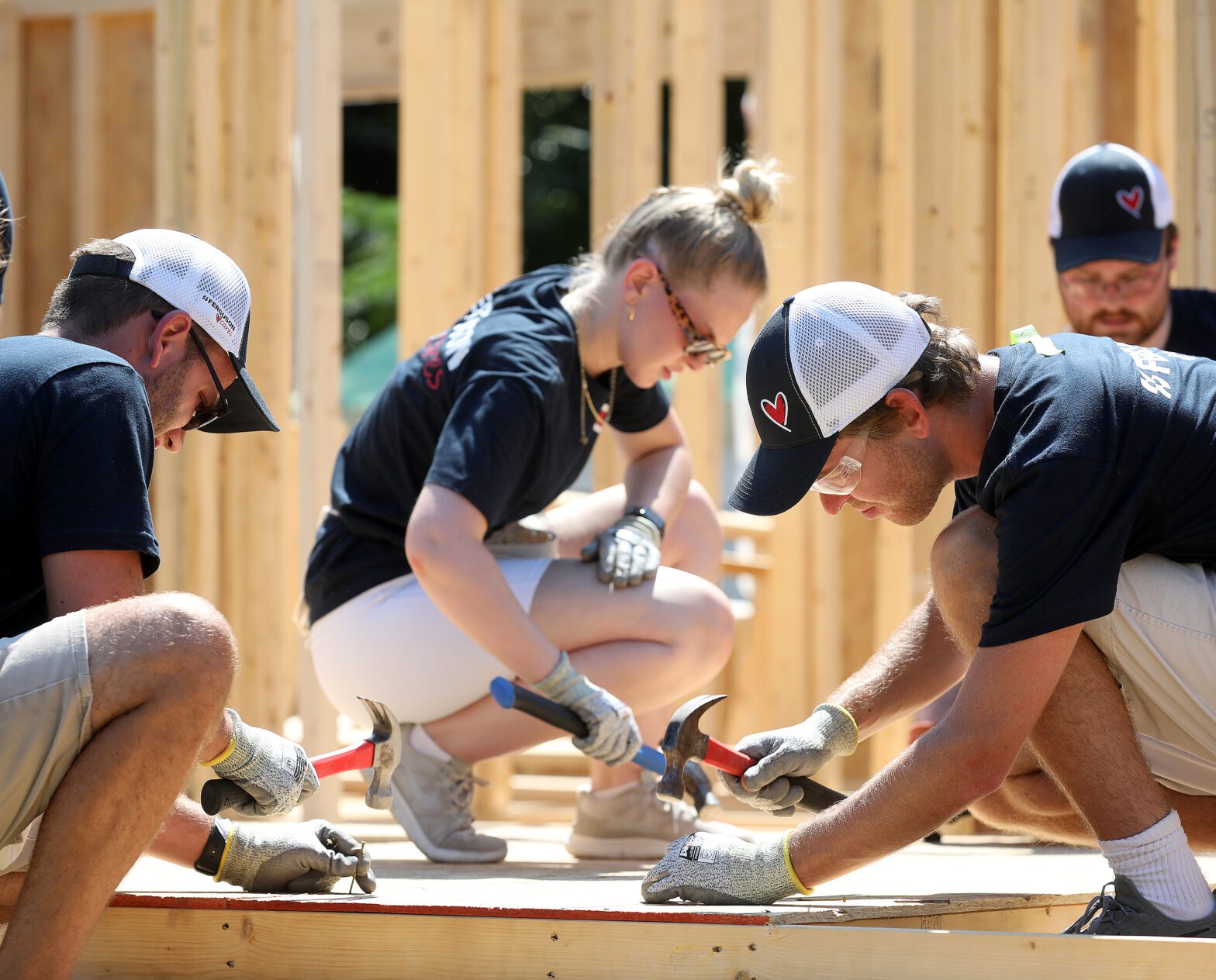 Ferguson team lifting a wall frame together during build.