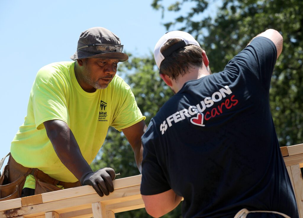 Ferguson volunteers discuss framing plans during Habitat build.