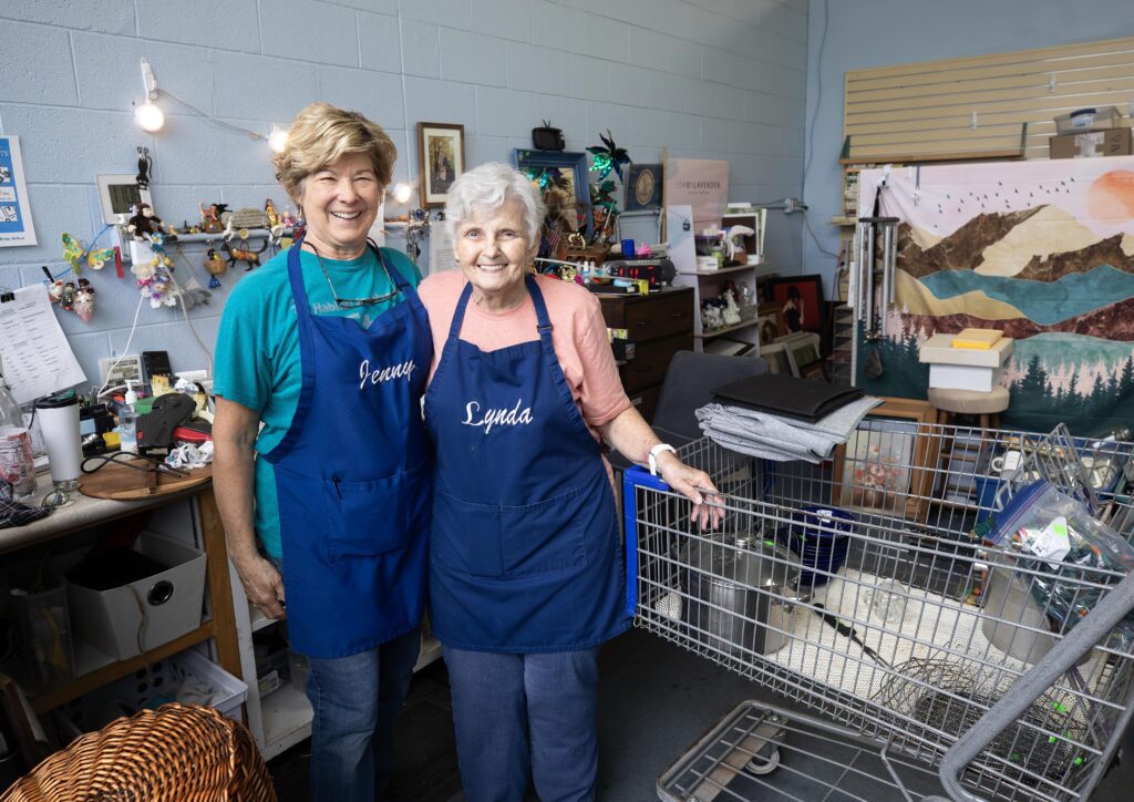Jenny McCauley and Lynda Schroeder smiling in the ReStore with their shopping cart project.