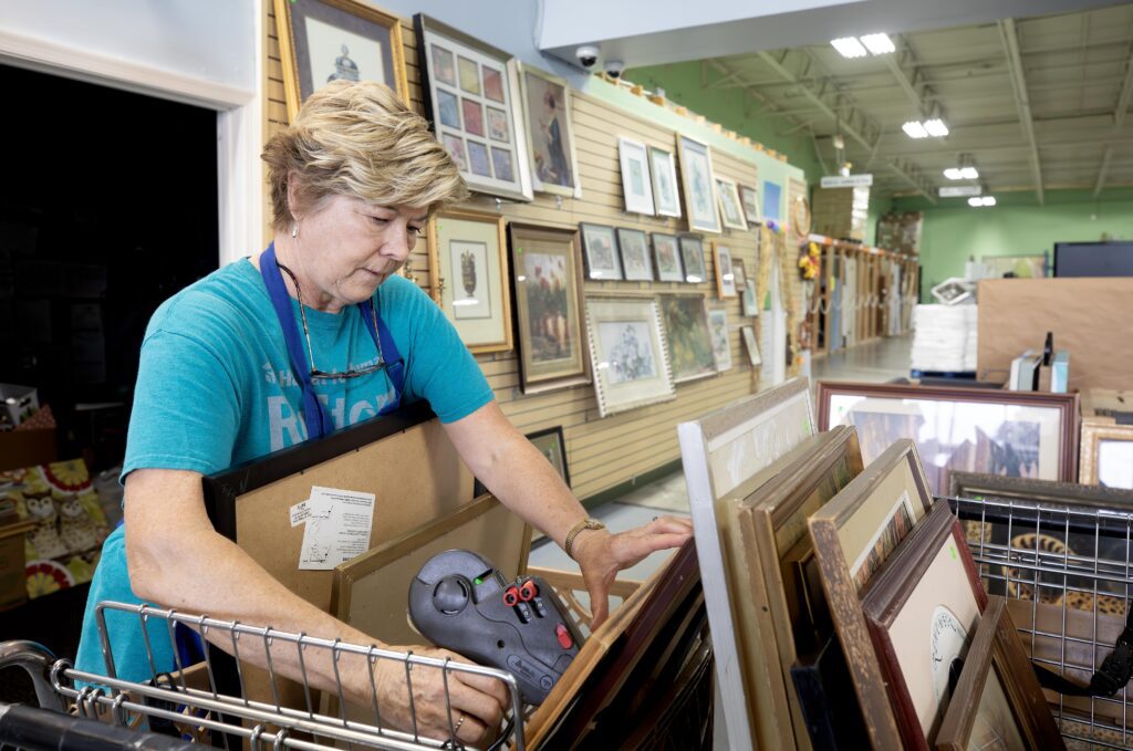 Jenny McCauley sorts and prices picture frames from incoming donations.
