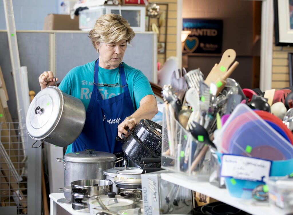 Jenny McCauley organizes donated kitchenware in the ReStore's home goods section.