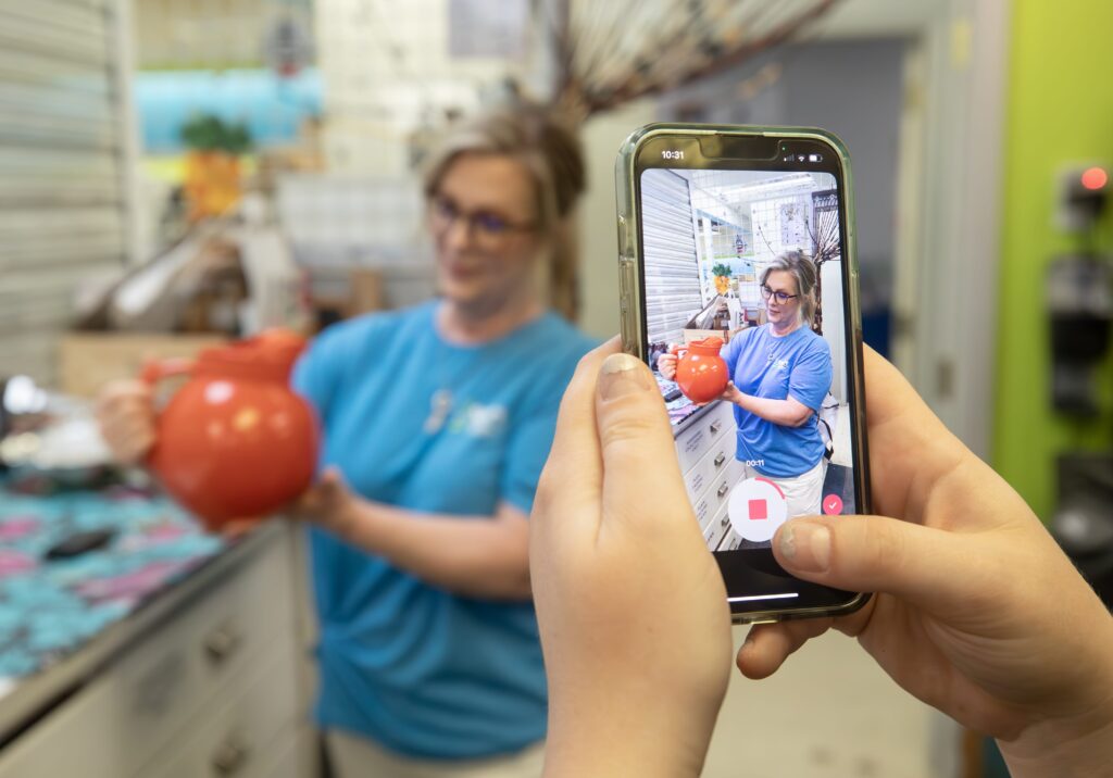 Nancy Cowhey filming a TikTok video at ReStore.