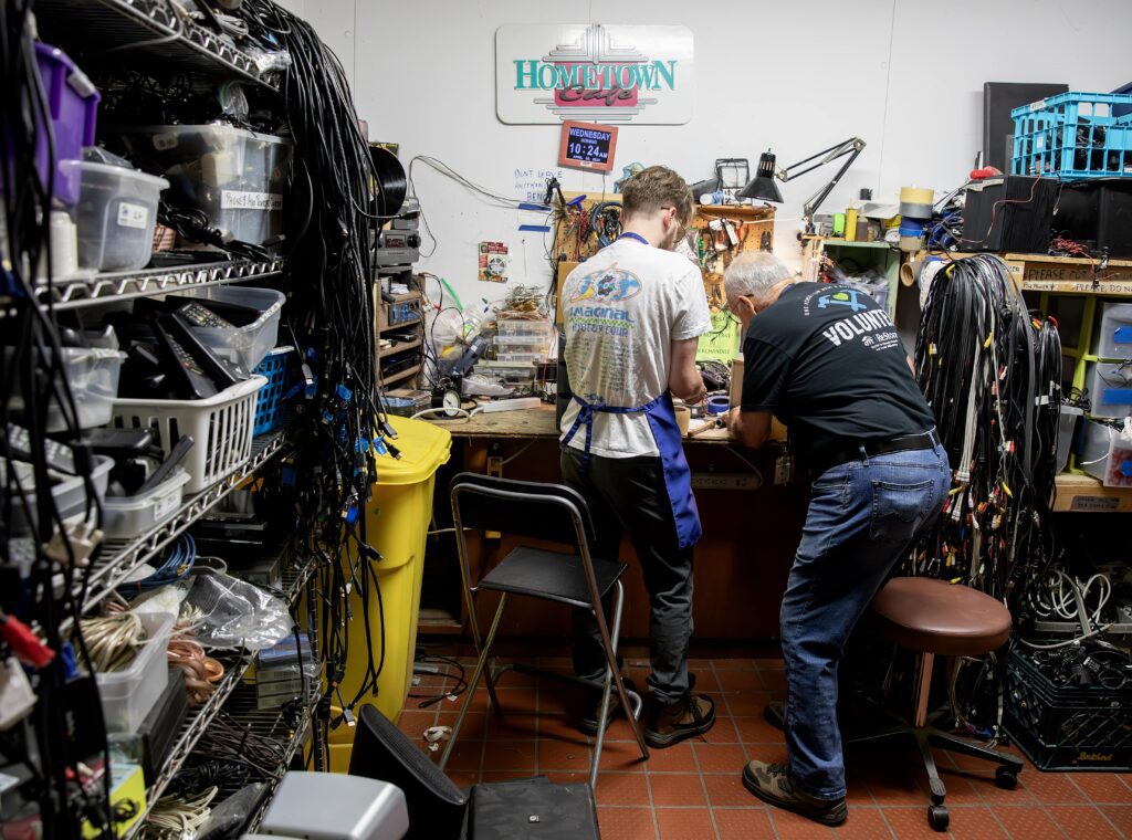 Tim McSwain and fellow volunteer organizing electronics.
