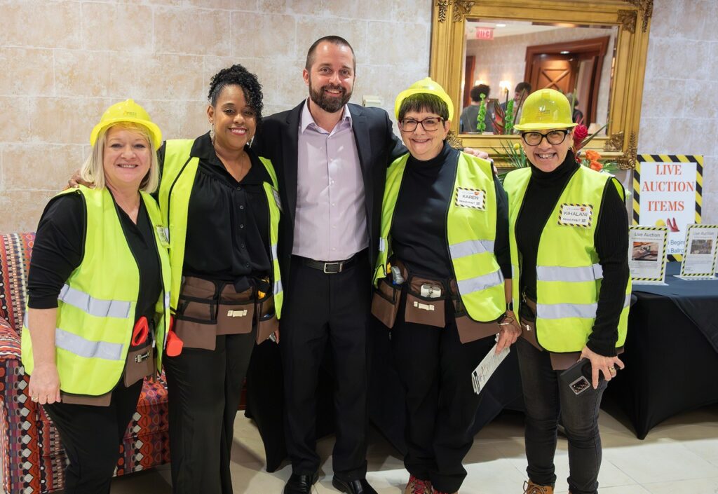 People posing in construction outfits.