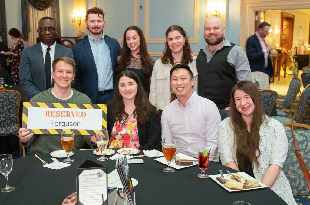 A group of people from Ferguson sitting at a table and standing. 