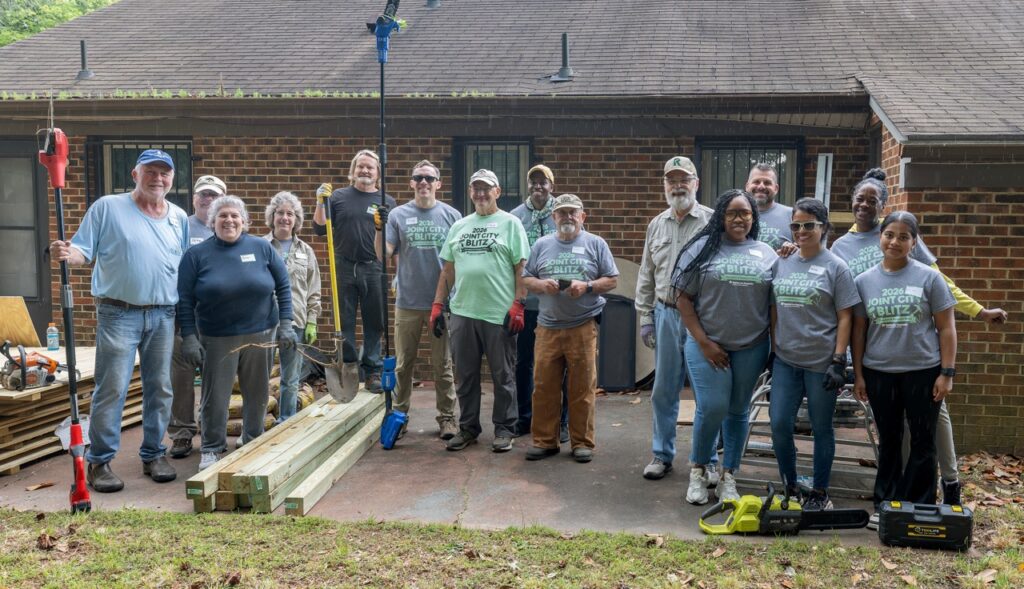 Group of people posing for a photo outside a Habitat for Humanity Home Repair Blitz site