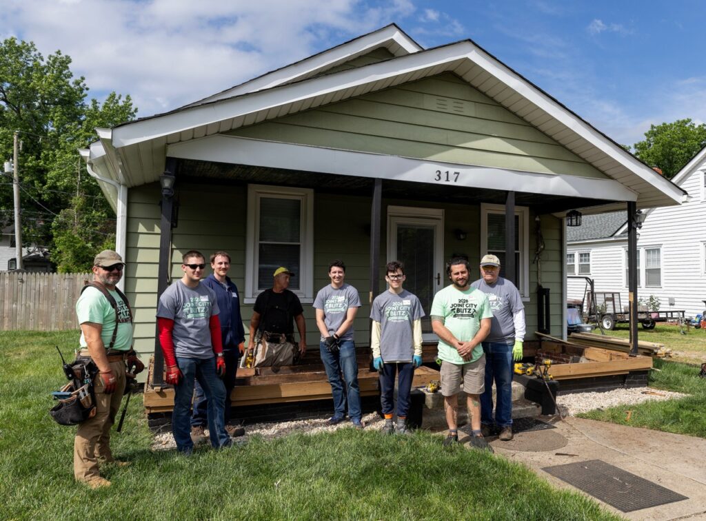Group of people posing for a photo outside a Habitat for Humanity Home Repair Blitz site