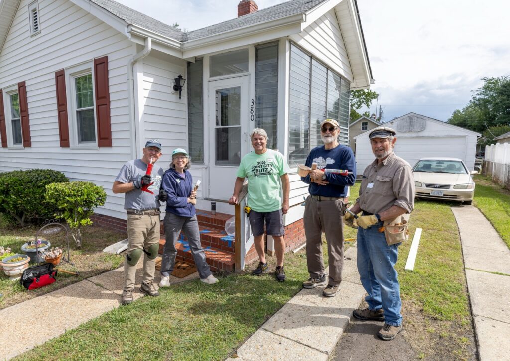 Group of people posing for a photo outside a Habitat for Humanity Home Repair Blitz site