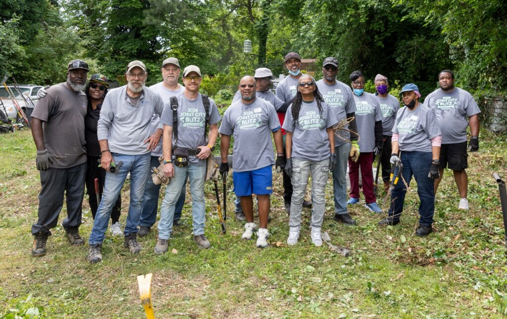 Group of people posing for a photo outside a Habitat for Humanity Home Repair Blitz site