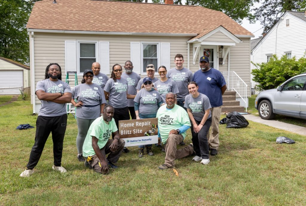 Group of people posing for a photo outside a Habitat for Humanity Home Repair Blitz site