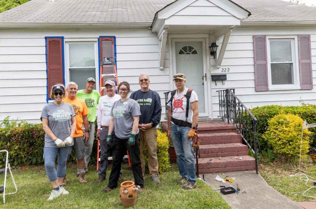 Group of people posing for a photo outside a Habitat for Humanity Home Repair Blitz site